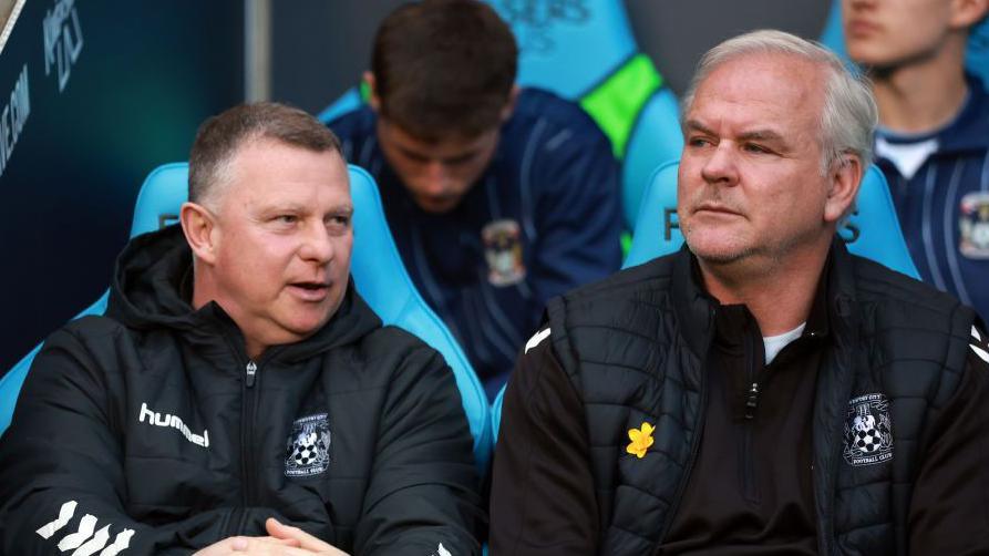 Mark Robins and Adi Viveash sat on the dugout together at Coventry