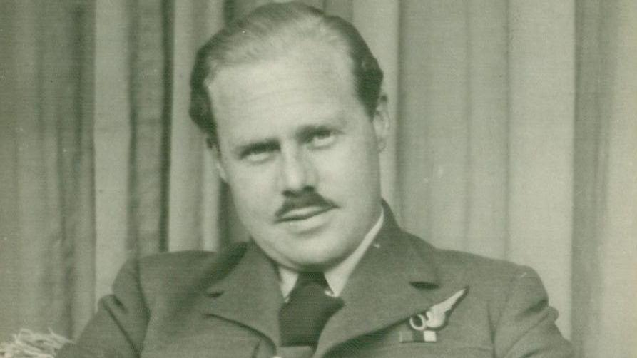 A young Alan Green looks at the camera, dressed in his RAF uniform. His hair is smartly combed back, and he sports a moustache.