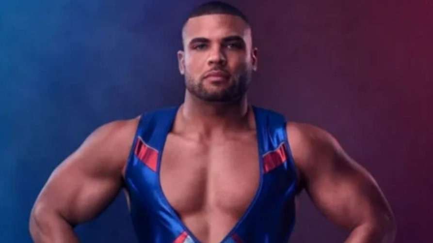 A man in a gymnastics leotard standing with his hands on his hips. 