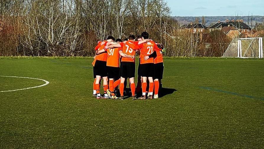 New Dad's United in a team huddle on the pitch