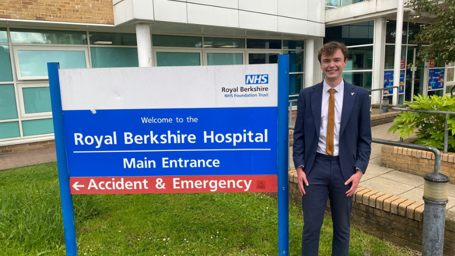 MP Henry Wright standing in a suit next the the Royal Berkshire Hospital sign outside the hospital