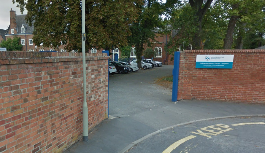 Bricked entrance to school with sign on one of the walls