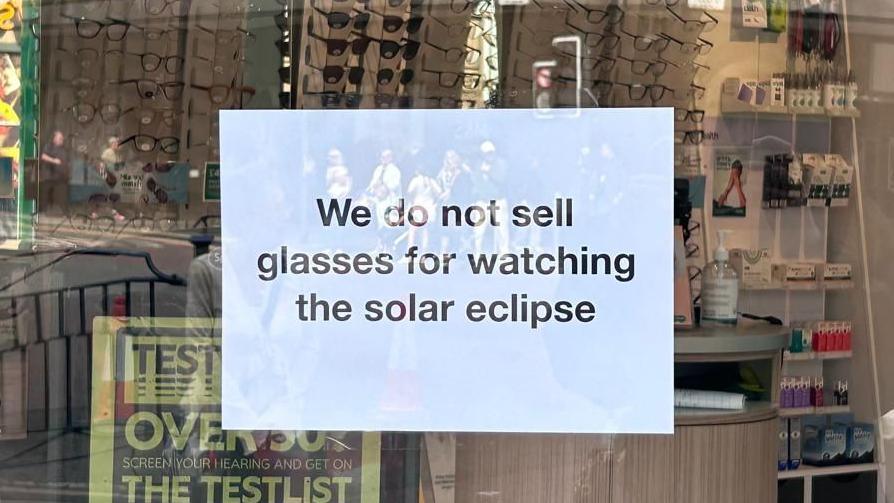 A sign in a shop window which reads: "We do not sell glasses for watching the solar eclipse".
