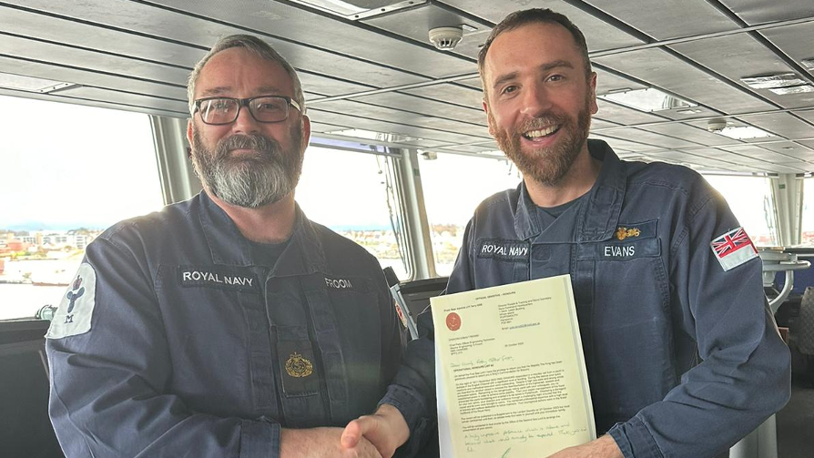 Chief Petty Officer Stephen Froom shaking hands with Commander Peter Evans