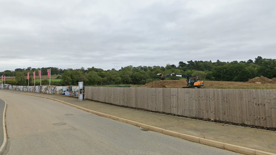Diggers on the estate, with fencing along the road side