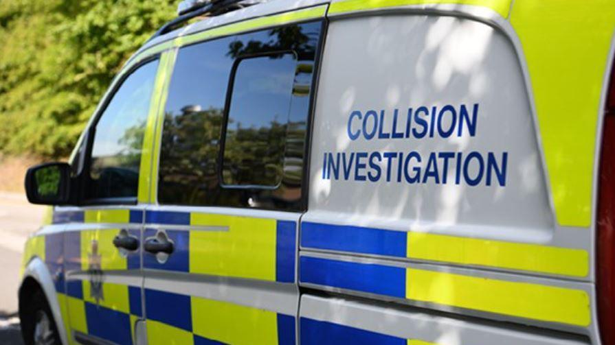 An angled-side view of a blue and yellow police-marked van. It has writing reading 'collision investigation' on its left side.