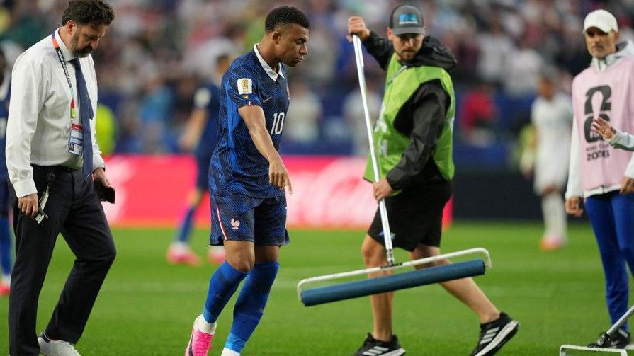 Kylian Mbappe points out waterlogged areas of the pitch to ground staff at Philadelphia Stadium