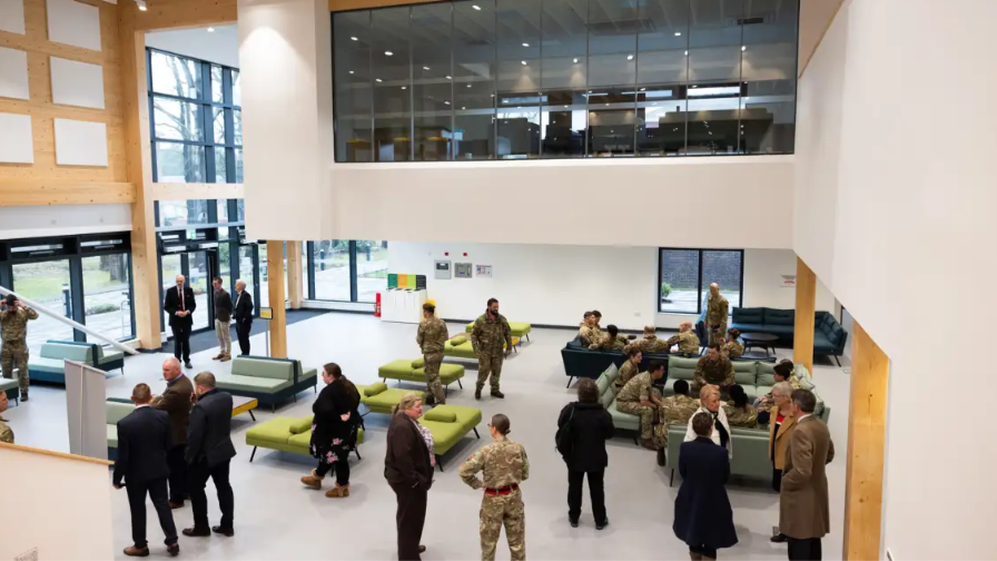 A wide shot of the new facility. You can see around 30 people, some in Army uniform, others in suits. 