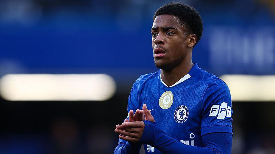 Ryan Kavuma-McQueen applauds the fans at a Chelsea game
