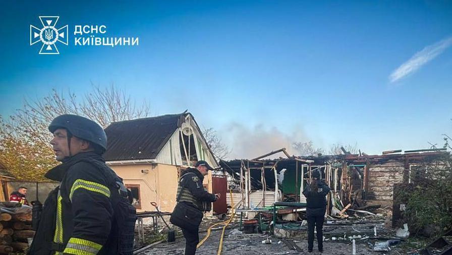 Firefighters outside the wreckage of a burned out home near Kyiv