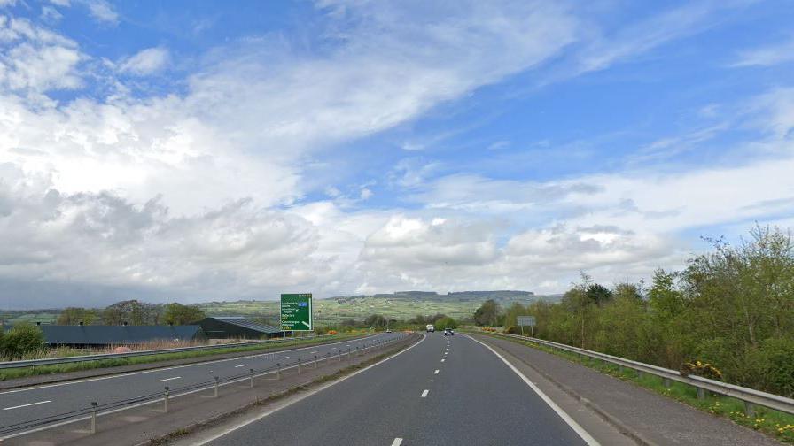 An A road with no cars on it. The sky is blue with some clouds. 