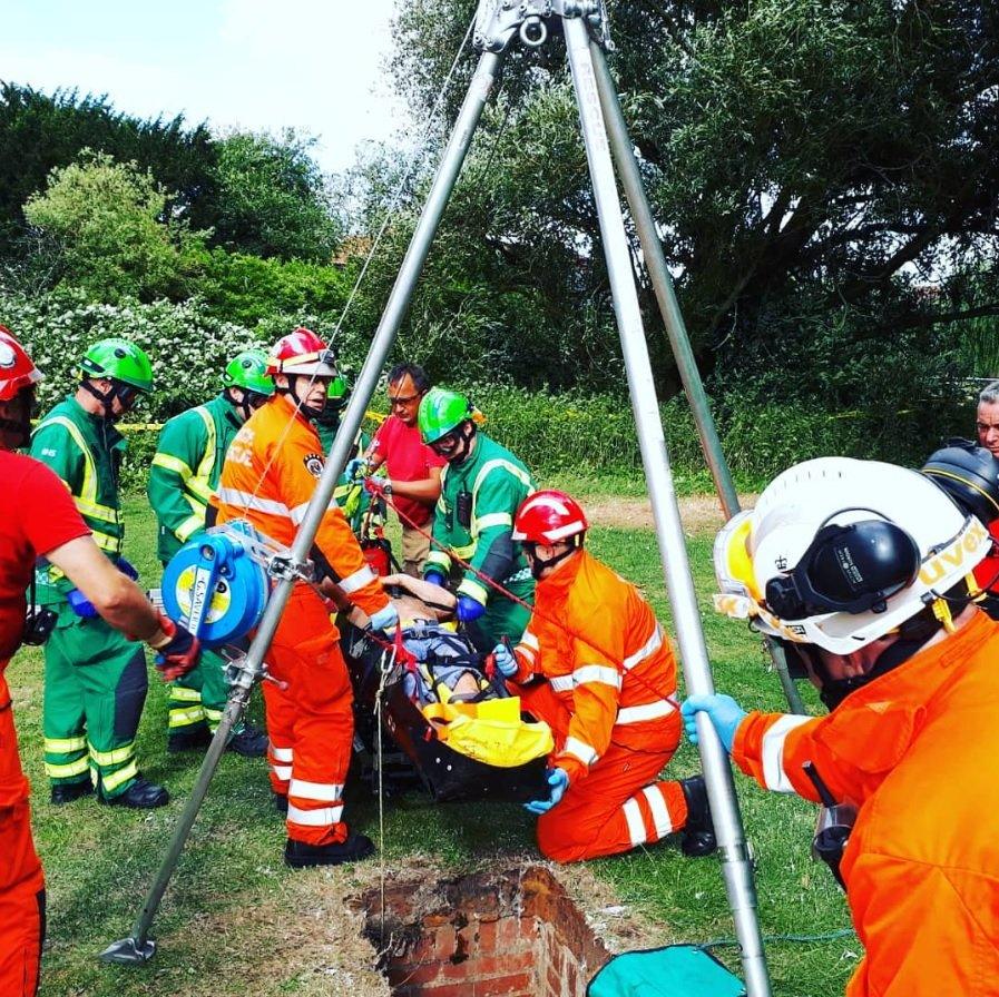 Emergency crews lift a patient out of a well shaft.