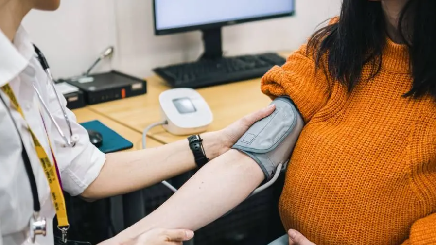 Generic image of a doctor taking a pregnant woman's blood pressure.