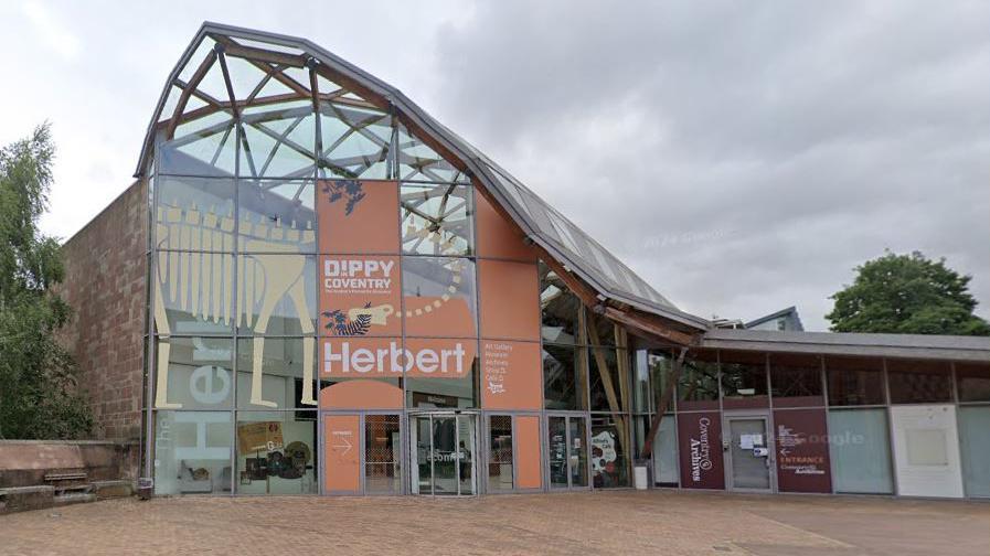 A large glass building with the word Herbert above the main entrance.