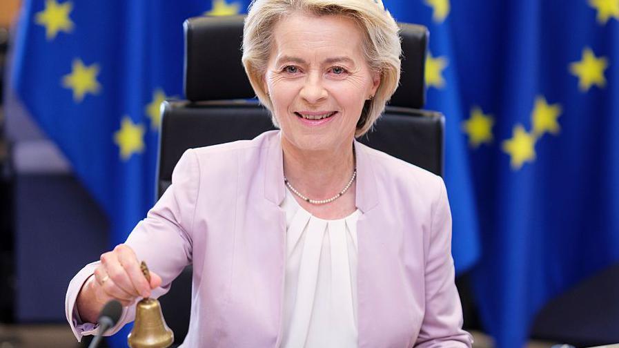 President of the European Commission Ursula von der Leyen calls her colleagues prior to the weekly EU Commission College meeting by holding a small golden bell and smiling.