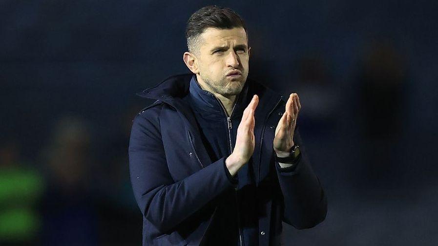 John Mousinho claps supporters at the end of a game