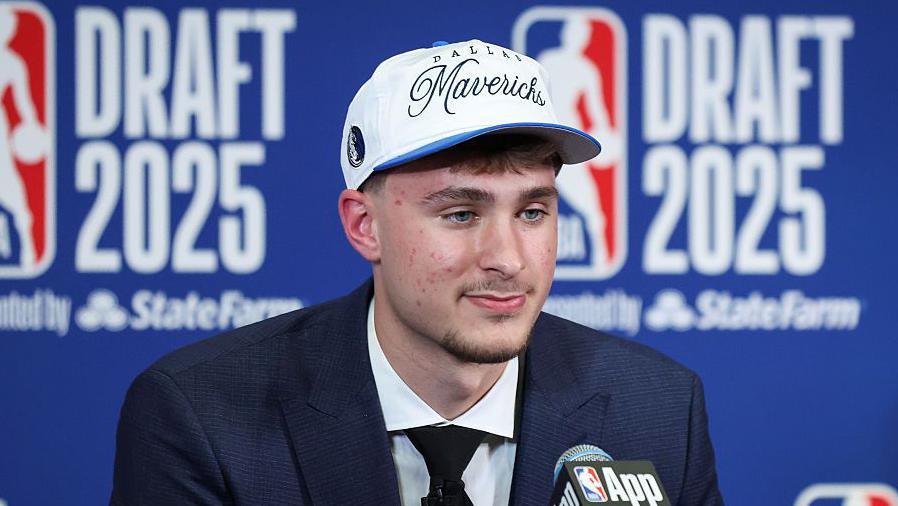 Cooper Flagg wearing a Dallas Mavericks baseball cap
