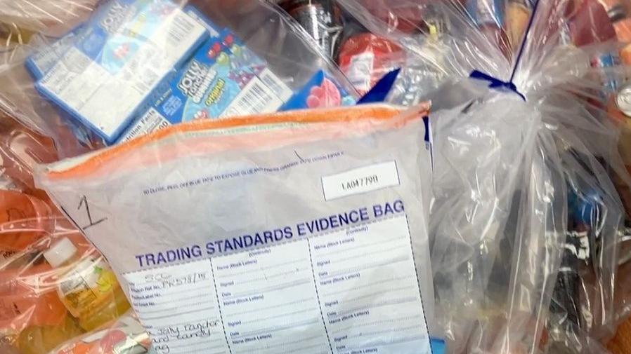 A trading standards evidence bag and clear bags containing banned Jolly Rancher sweets and drinks.