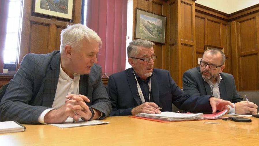 Coventry council leader George Duggins and cabinet member for finance Richard Brown sat at a table in the Council House