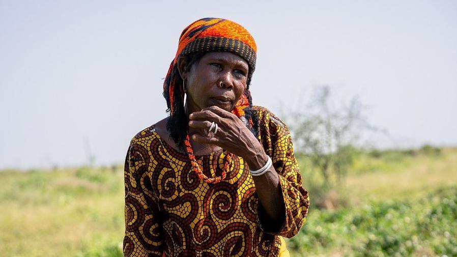 Aisha Isa stands near on plot in Darwa village.