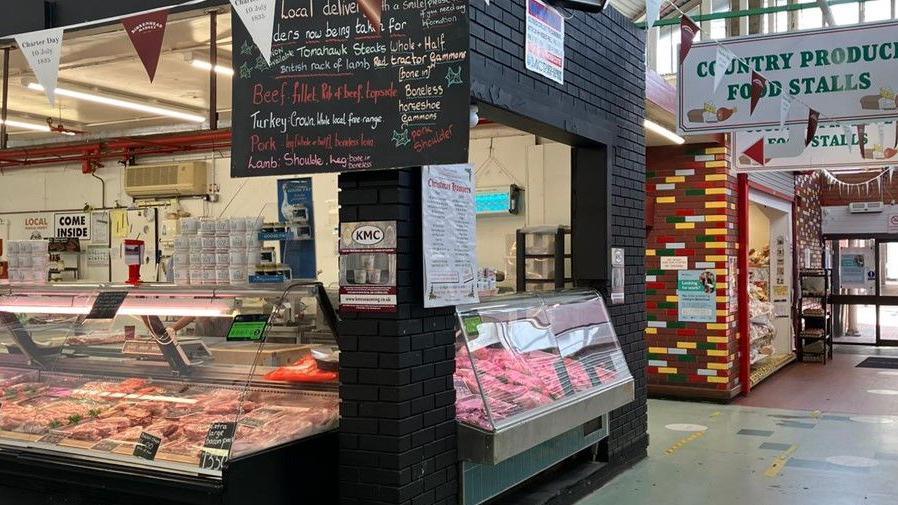 Image shows a butcher's stall at Birkenhead indoor market