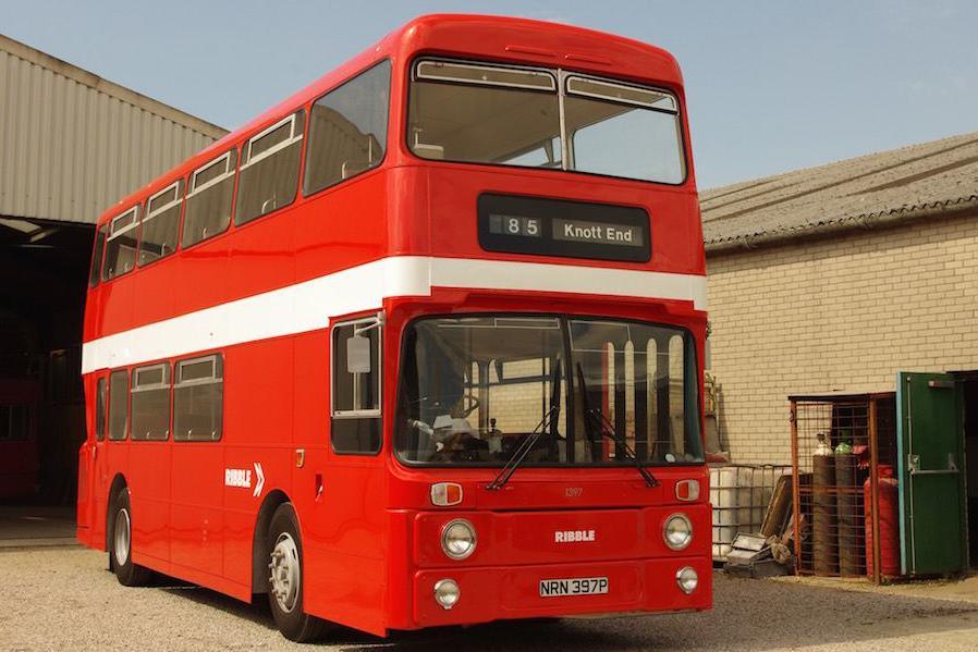 A vintage double decker bus. It is painted bright red and the sign on the front reads: "85 Knott End".