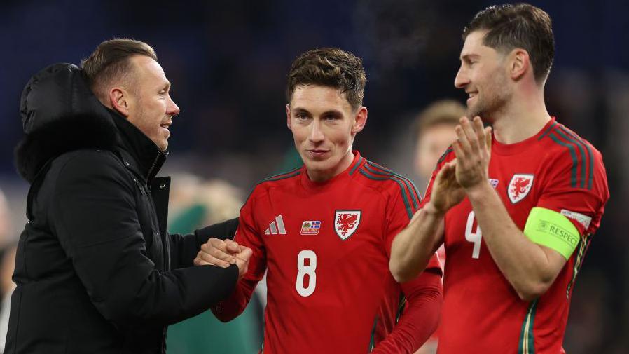 Craig Bellamy, Harry Wilson and Ben Davies celebrate a Wales win 