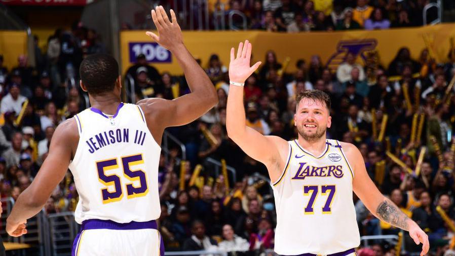 Luka Doncic high-fiving team-mate Trey Jemison III