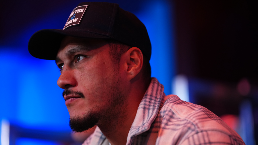 Jai Opetaia looks on at ringside in a baseball cap