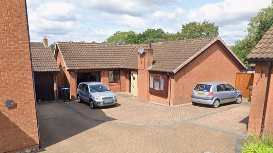 A Google Maps street view image of a bungalow. Two cars are parked outside.