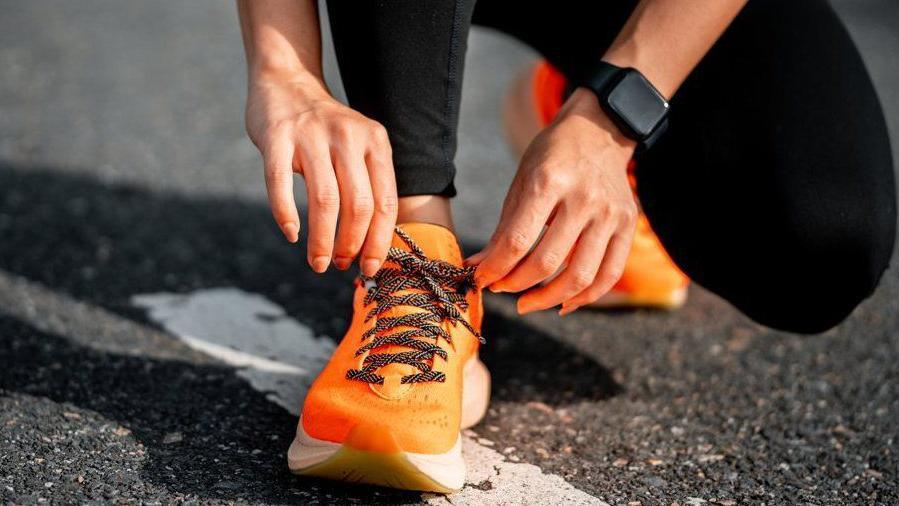 Woman tying shoelace