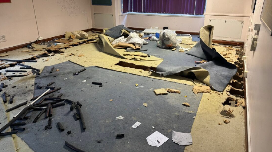 Litter and ripped out carpets inside the building 