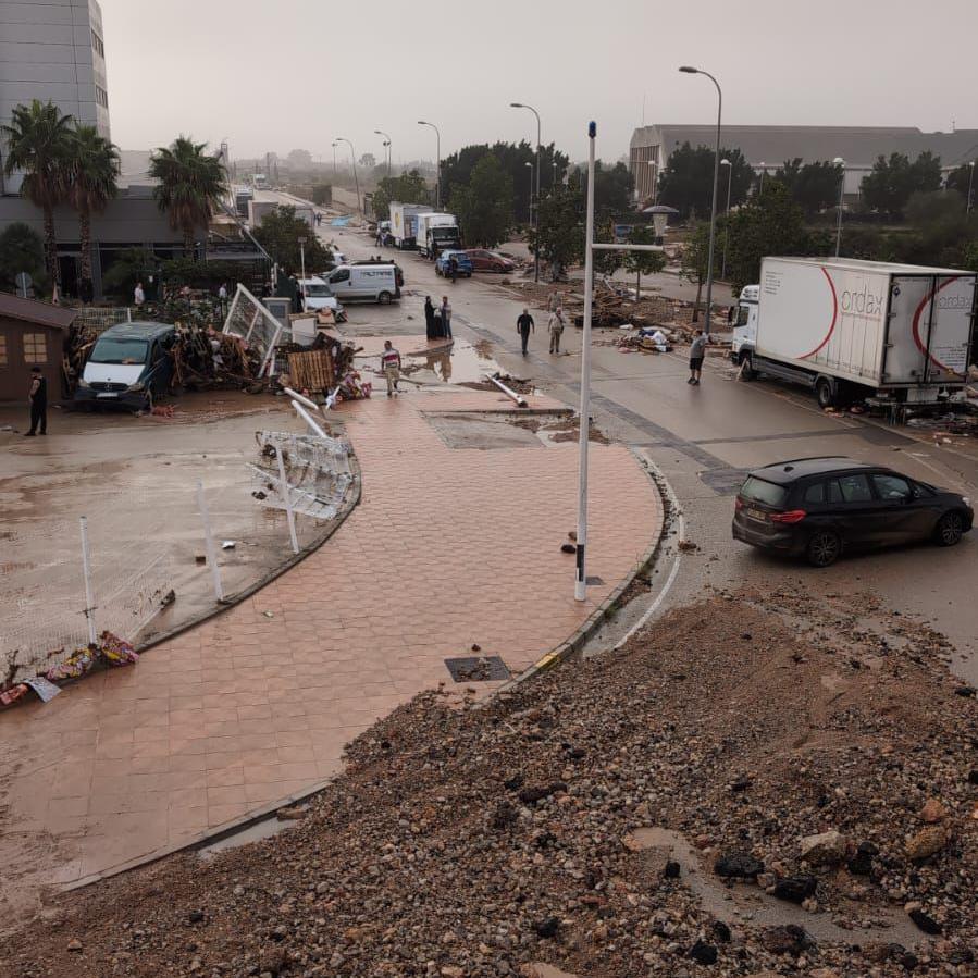 Damage caused by the floodwater. There is a pile of mud in the foreground and debris strewn everywhere