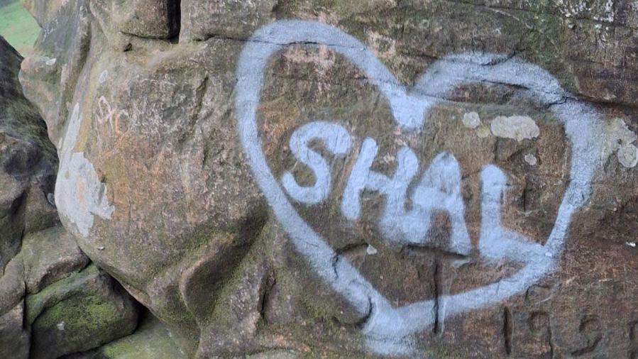 The name Shal daubed in paint on a cave wall