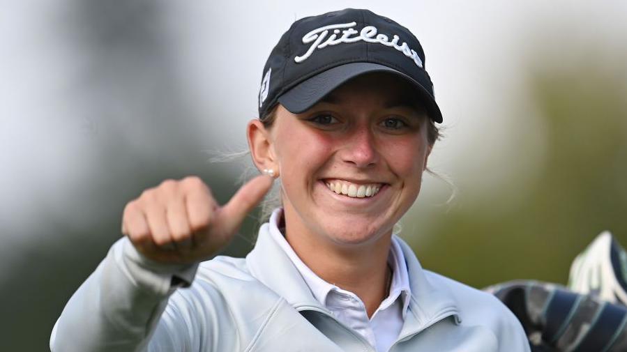 Amy Taylor smiles and gives a thumbs-up