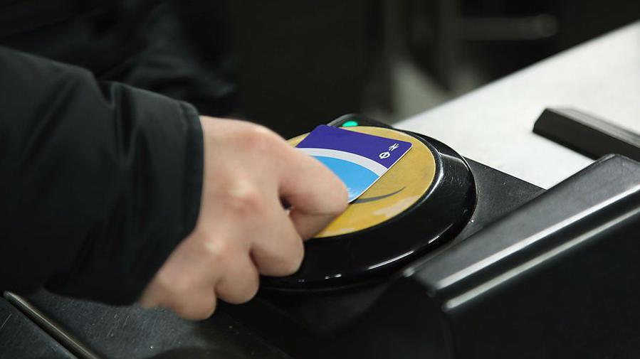 A commuter swipes his Oyster card at a London Underground station