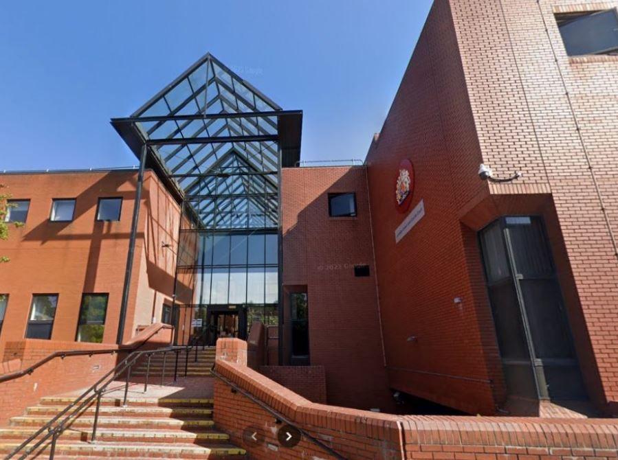 A red brick court building, with high glass frontage and sweeping steps leading to the entrance. The building is bathed in sunlight.