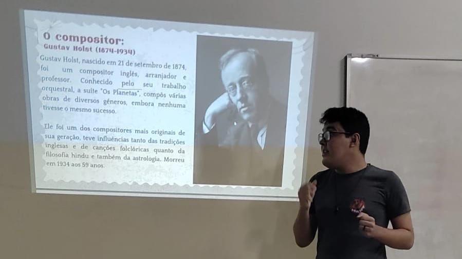 Bruno Lima giving a presentation on Gustav Holst at a university