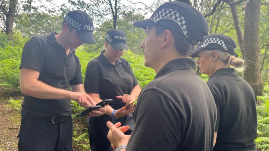 A group of police officers in woodland