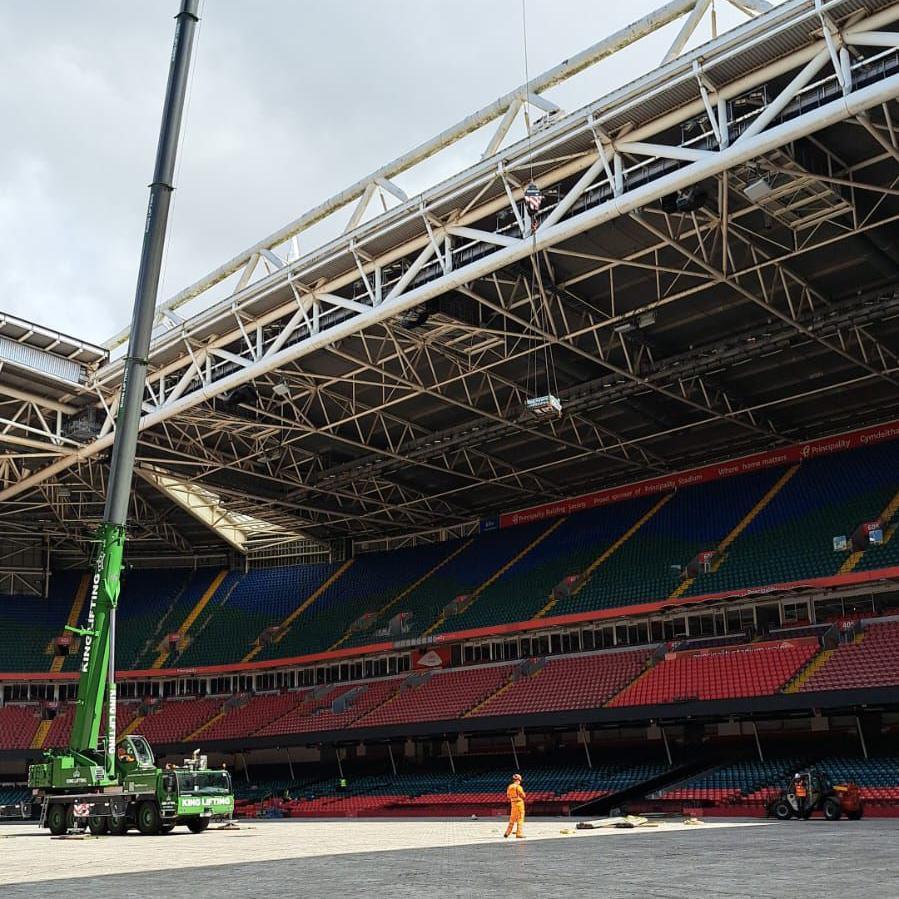 Craen yn codi paneli solar o gae Stadiwm Principality drwy'r agoriad yn y to