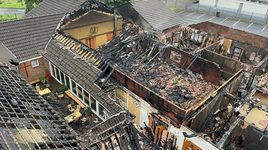 Aerial shot of fire damaged church with roof missing