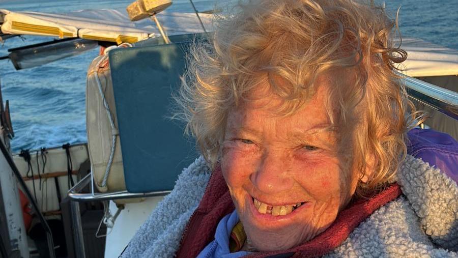A close up portrait of Dot, who smiles while sat on a boat.