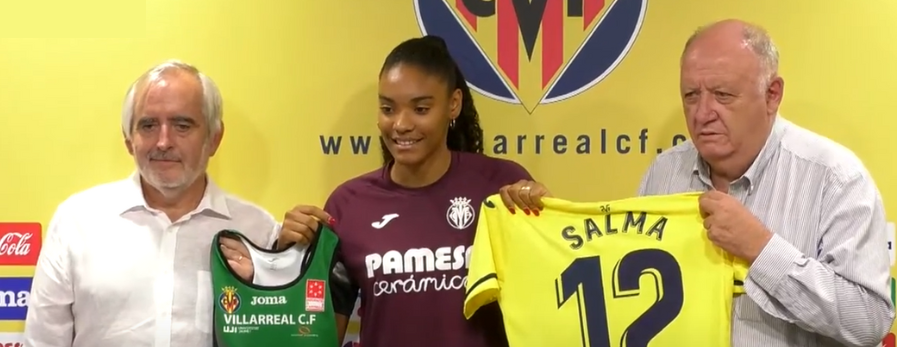 Salma holds up the shirts of Playas de Castellon athletics club and Villarreal after signing a dual contract 