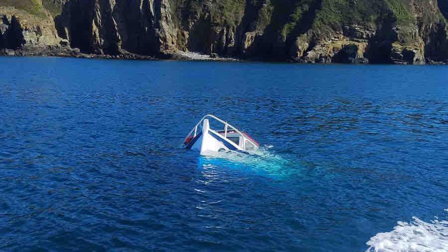 The tip of a sunken boat poking out the ocean off the coast of Sark.