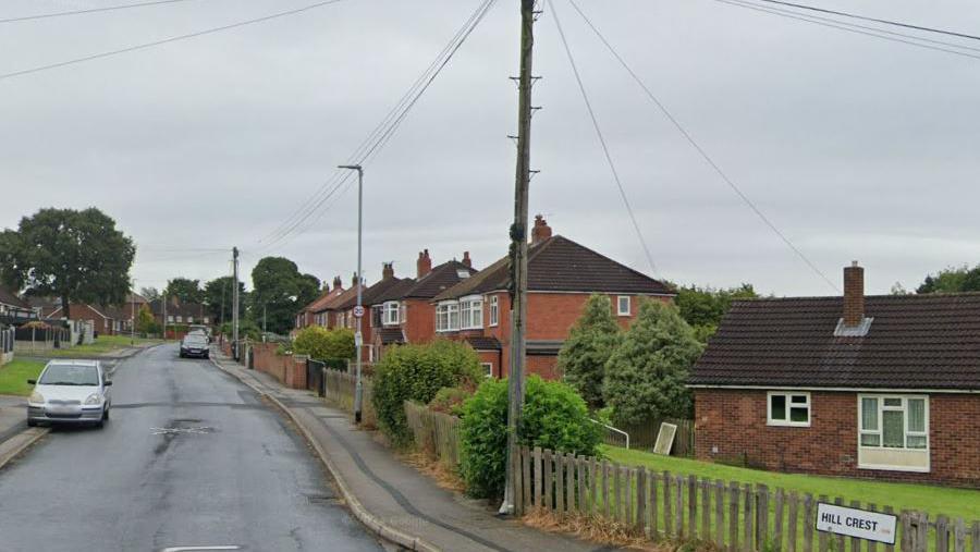 Hill Crest Swillington. The picture shows a gradually inclining upwards road with parked cars and houses