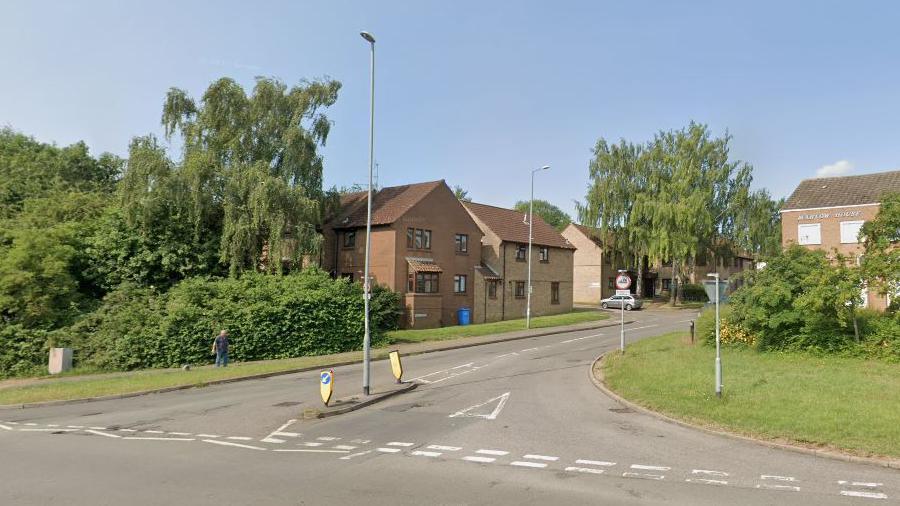 The road junction to Gold Street, with 1980s houses and flats on one side and slightly older style flats on the other.