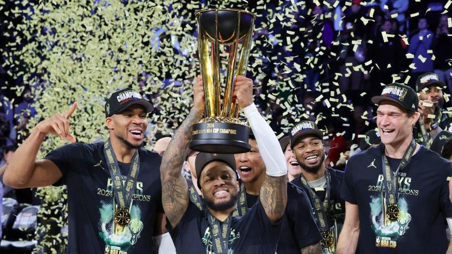 Damian Lillard lifts the NBA Cup while his Milwaukee Bucks team-mates celebrate 