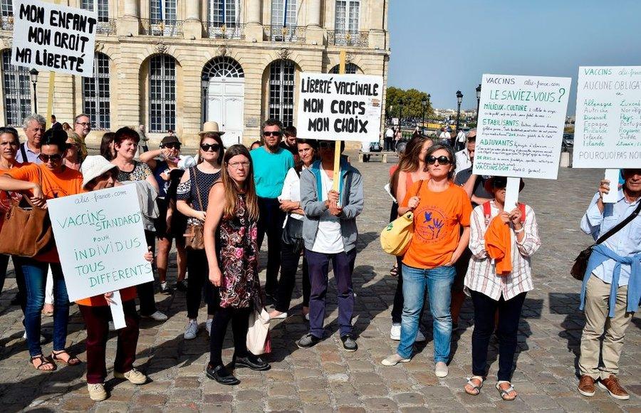 Anti-vax protesters demonstrate with placards.