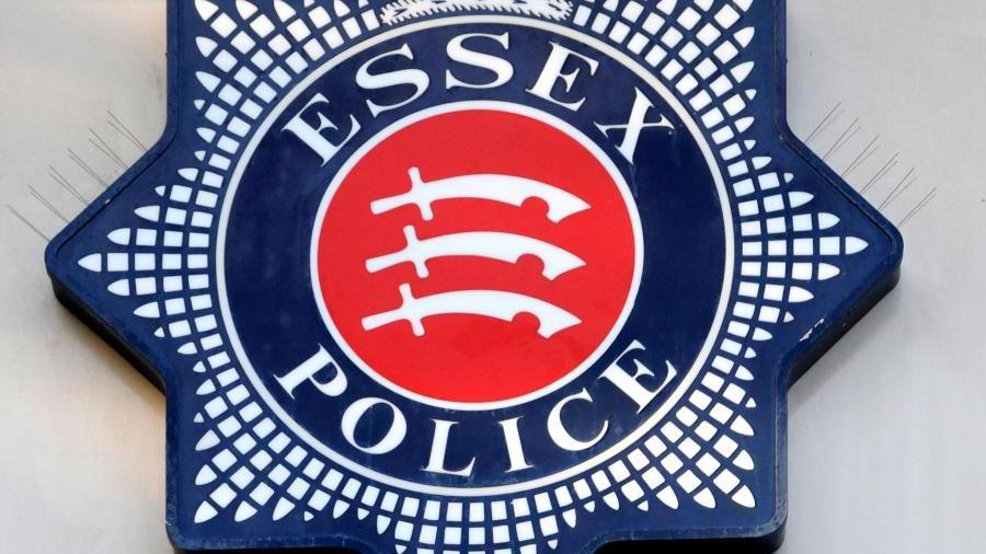 A star-shaped blue badge with "Essex Police" written either side of a red circle