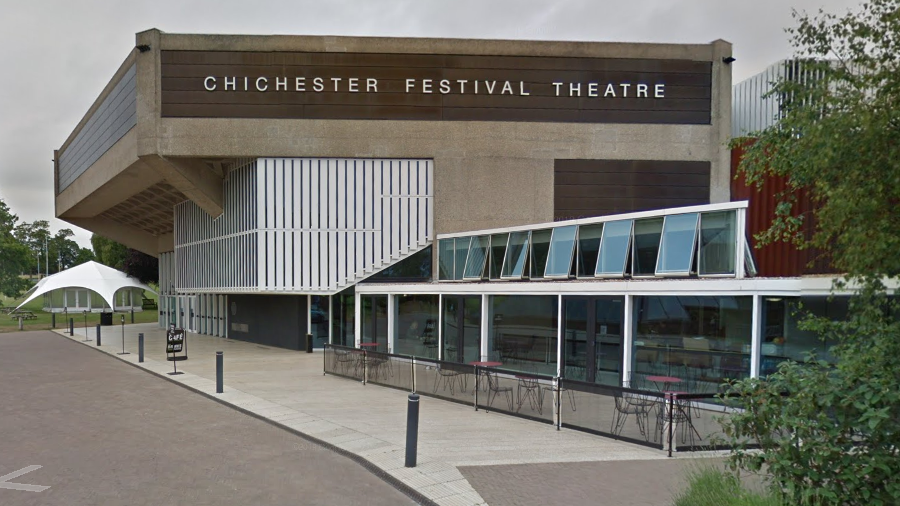 An exterior image of the Chichester Festival Theatre in Chichester. The building has a brown panel emblazoned with 'Chichester Festival Theatre'.